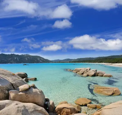 a view of a beach with rocks in the water at Golden Tulip Porto-Vecchio in Porto-Vecchio