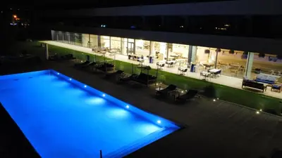 a large building with a swimming pool at night at Golden Tulip Porto-Vecchio in Porto-Vecchio