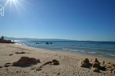 a beach with rocks in the sand and the ocean at Carlota - Appartement rénové au cœur de la vieille ville - by TGB in Ajaccio