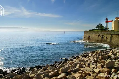 a rocky shore with a lighthouse and the ocean at Carlota - Appartement rénové au cœur de la vieille ville - by TGB in Ajaccio