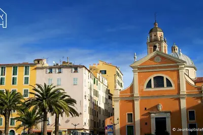 a building with a clock tower in front of buildings at Carlota - Appartement rénové au cœur de la vieille ville - by TGB in Ajaccio