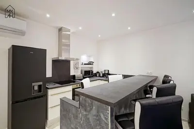 a kitchen with a counter and a black refrigerator at Carlota - Appartement rénové au cœur de la vieille ville - by TGB in Ajaccio