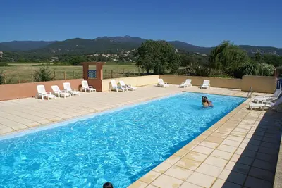 a dog is swimming in a swimming pool at Résidence Marina di Capitello in Porticcio
