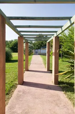 a concrete walkway in a park with awning at Résidence Marina di Capitello in Porticcio