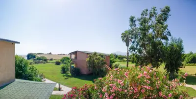 a view of a yard with a house and flowers at Résidence Marina di Capitello in Porticcio