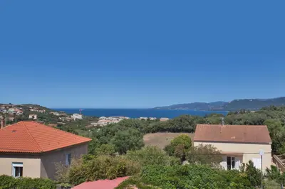 a view of a city with houses and the ocean at Résidence Villa Romana avec Piscine et Jacuzzi in Propriano