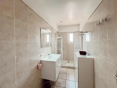 a bathroom with a white sink and a shower at Résidence Villa Romana avec Piscine et Jacuzzi in Propriano