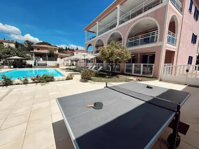 a ping pong table in front of a building at Résidence Villa Romana avec Piscine et Jacuzzi in Propriano