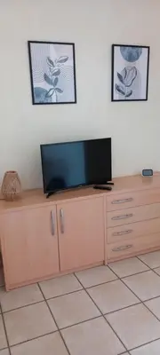 a flat screen tv sitting on top of a wooden cabinet at Résidence Villa Romana avec Piscine et Jacuzzi in Propriano