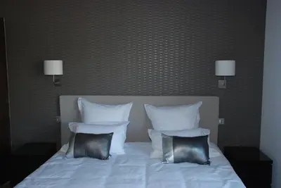 a bed with white sheets and two pillows at Hôtel & Résidence Les Bergeries d'Alata in Alata