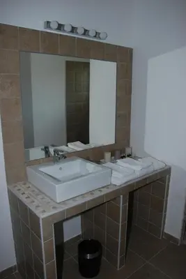 a bathroom with a sink and a mirror at Hôtel & Résidence Les Bergeries d'Alata in Alata