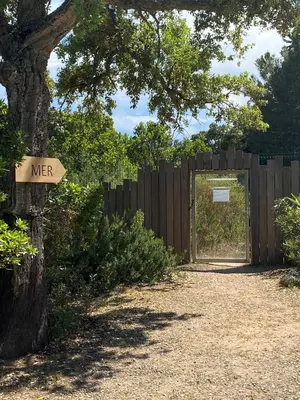 a wooden gate with a sign that reads nearer at Résidence Cala Sultana Appartement T2 in Porto-Vecchio