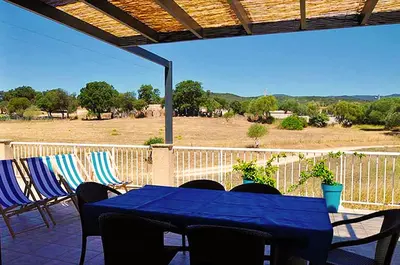 a patio with a table and chairs on a balcony at Résidence Casa Favalella in Porto Pollo