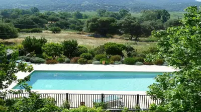a swimming pool in a garden with a fence at Résidence Casa Favalella in Porto Pollo