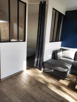 a living room with a couch and a mirror at Superbe T1 neuf avec vue mer sur Marinella in Ajaccio