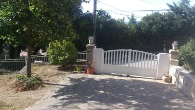 a white fence in a yard with a tree at Belle maison de charme ancien, vue mer et montagne in Casalabriva