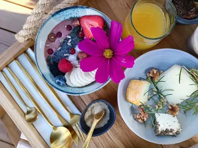 a table with two plates of food and a flower on it at Hôtel Les Suites Du Maquis in Bonifacio