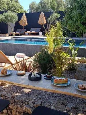 a tray of food on a table next to a pool at Hôtel Les Suites Du Maquis in Bonifacio
