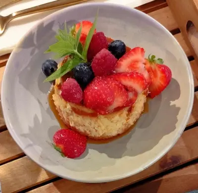 a white plate with a pastry with strawberries and berries at Hôtel Les Suites Du Maquis in Bonifacio