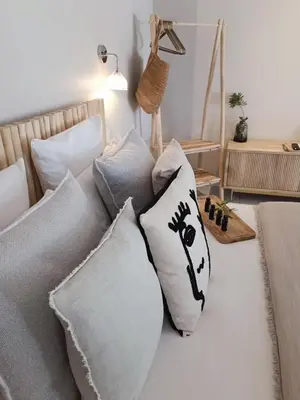 a bed with pillows on it in a room at Hôtel Les Suites Du Maquis in Bonifacio
