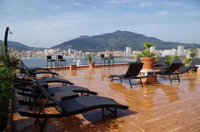 a patio with chairs and a view of a city at Hôtel Spunta Di Mare in Ajaccio