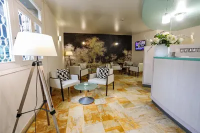 a room with a waiting room with chairs and a table at Hôtel Spunta Di Mare in Ajaccio