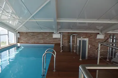 a pool in a building with a brick wall at Hôtel Spunta Di Mare in Ajaccio
