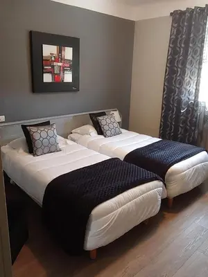 two beds sitting next to each other in a room at Hôtel Spunta Di Mare in Ajaccio
