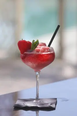 a drink with a strawberry in a martini glass at Hôtel San Lucianu in Moriani Plage