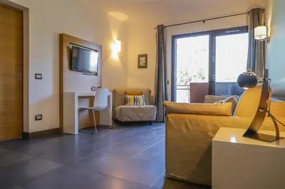 a living room with a couch and a table at Hôtel San Lucianu in Moriani Plage