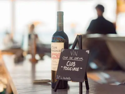 a bottle of wine sitting on top of a table at Hôtel San Lucianu in Moriani Plage