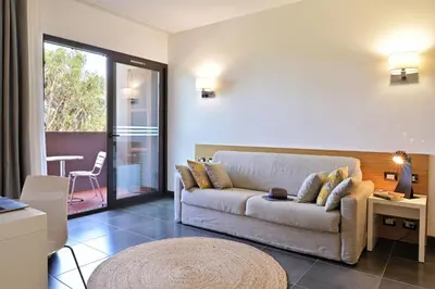 a living room with a couch and a table at Hôtel San Lucianu in Moriani Plage