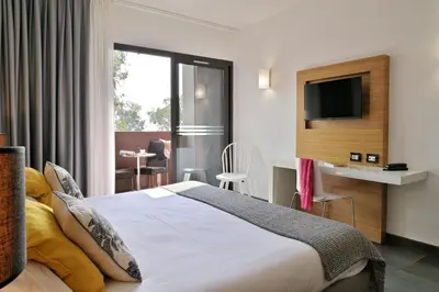 a hotel room with a bed and a television at Hôtel San Lucianu in Moriani Plage