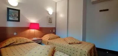 a hotel room with two beds and a lamp at VILLA ANGELINI in Valle-di-Campoloro