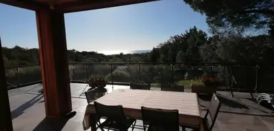 a table and chairs on a patio with a large window at VILLA ANGELINI in Valle-di-Campoloro