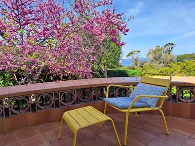 a yellow chair and a yellow chair on a balcony at Villa PLEIN SOLEIL- Plage d'Argent à 150 m - 150 m from beach in Coti-Chiavari