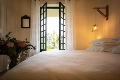 a bedroom with a large white bed and a window at Villa Milanu in Oletta