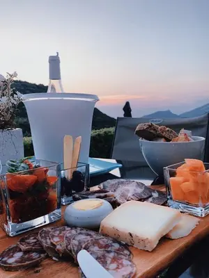 a wooden table with cheese and other foods on it at Villa Milanu in Oletta
