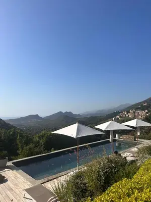 a swimming pool with umbrellas on top of it at Villa Milanu in Oletta