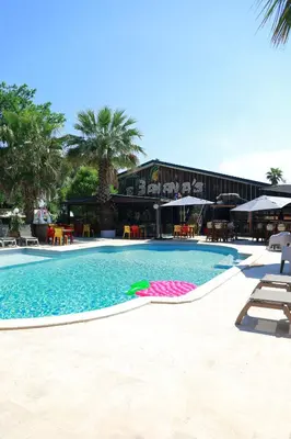 a large swimming pool with a building in the background at Le Banana's Hotel in Aléria