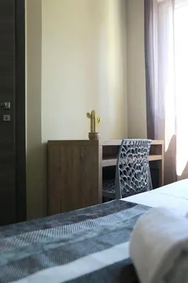 a bedroom with a bed and a desk with a cactus at Le Banana's Hotel in Aléria