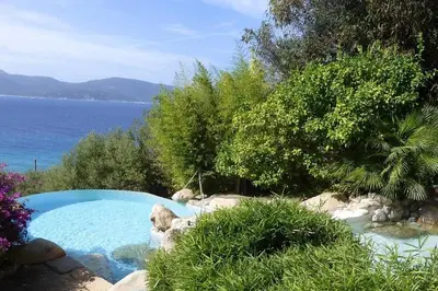 a living room with a couch and a table and chairs at Villas Valinco San Martinu Corse du Sud - vue et proche mer - piscines-7 chambres in Olmeto