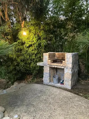 a stone oven in a garden next to trees at Villas Valinco San Martinu Corse du Sud - vue et proche mer - piscines-7 chambres in Olmeto