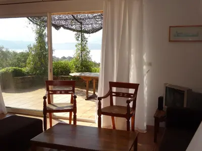 a living room with two chairs and a table and a window at Villas Valinco Capicciolo vue-proche mer-piscines in Olmeto