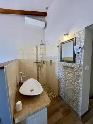 a bathroom with a sink and a shower with a mirror at L'Albadu in Corte