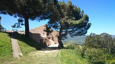 a house on the side of a hill with a tree at Hôtel 