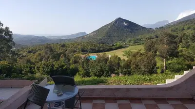 a patio with a table and chairs and mountains at Hôtel 