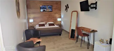 a bedroom with a bed and chairs in a room at Hôtel 