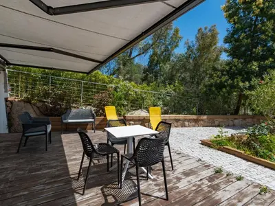 a patio with chairs and a table on a deck at Apartment Bastion-15 by Interhome in Porto-Vecchio