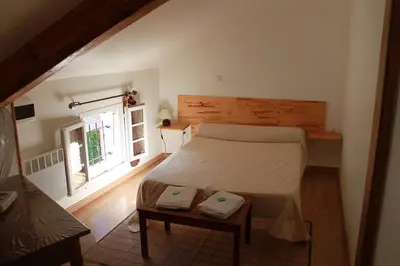 a bedroom with a large bed and a window at A MANDRIA, appartements avec cuisine 30m2, patio, vue Montagnes et citadelle, 5 minutes à pied du centre ville et des rivières in Corte